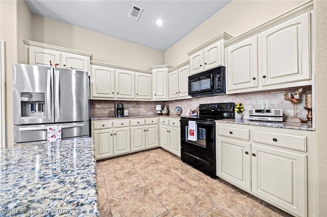 kitchen featuring visible vents, black appliances, backsplash, white cabinetry, and light stone countertops