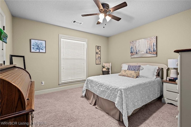 bedroom featuring visible vents, baseboards, ceiling fan, carpet floors, and a textured ceiling