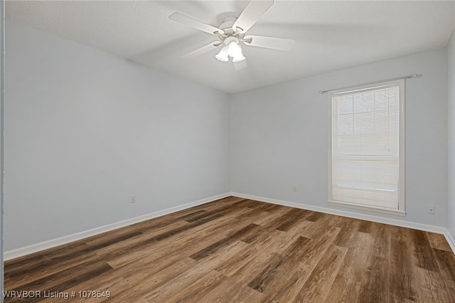 spare room featuring ceiling fan, dark hardwood / wood-style floors, and a textured ceiling