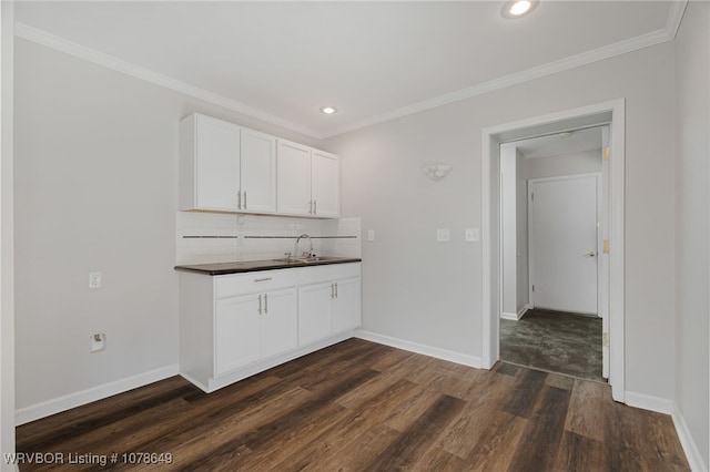 kitchen featuring white cabinetry, ornamental molding, dark hardwood / wood-style flooring, and tasteful backsplash