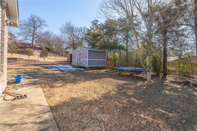 view of yard featuring a trampoline and a storage unit