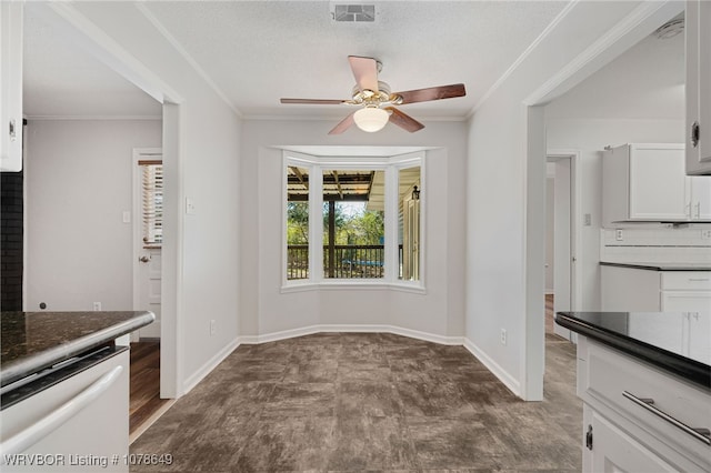 unfurnished dining area featuring a textured ceiling, ornamental molding, and ceiling fan