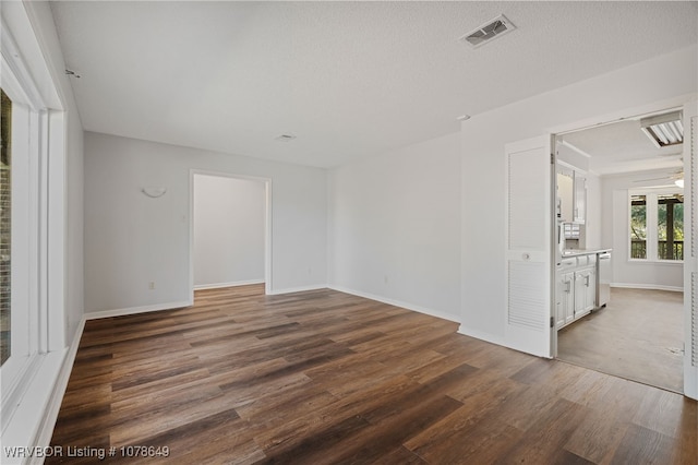 spare room featuring dark wood-type flooring and a textured ceiling