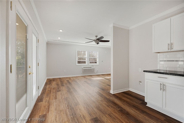 unfurnished living room featuring a wall mounted air conditioner, crown molding, dark wood-type flooring, and ceiling fan