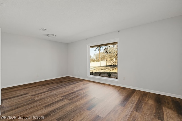 spare room with dark hardwood / wood-style flooring