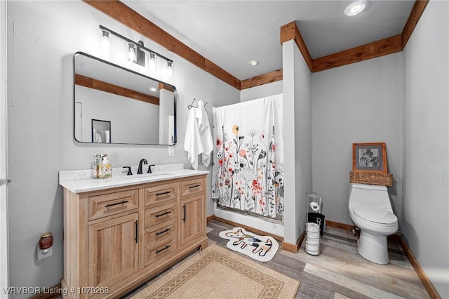 bathroom with vanity, wood finished floors, baseboards, a shower stall, and toilet