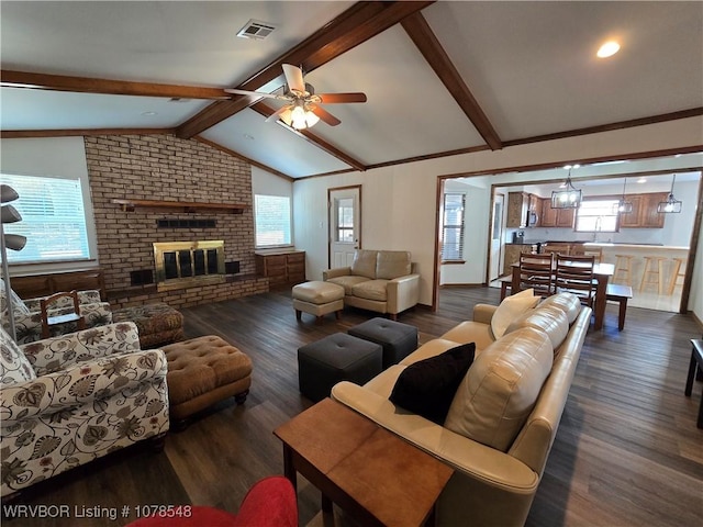 living room featuring lofted ceiling with beams, ceiling fan, a brick fireplace, and dark hardwood / wood-style flooring