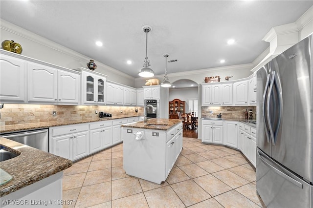 11805 Springridge Dr, Fort Smith, AR 72916 - kitchen featuring stainless steel appliances, arched walkways, tasteful backsplash, white cabinetry, and dark stone counters