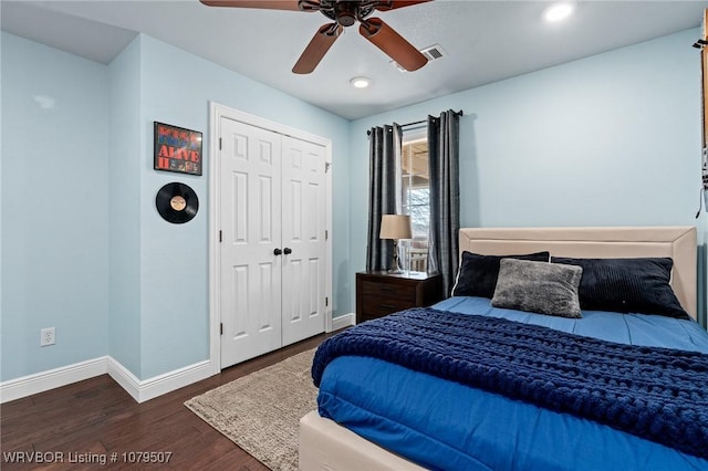 bedroom featuring wood finished floors, visible vents, baseboards, ceiling fan, and a closet