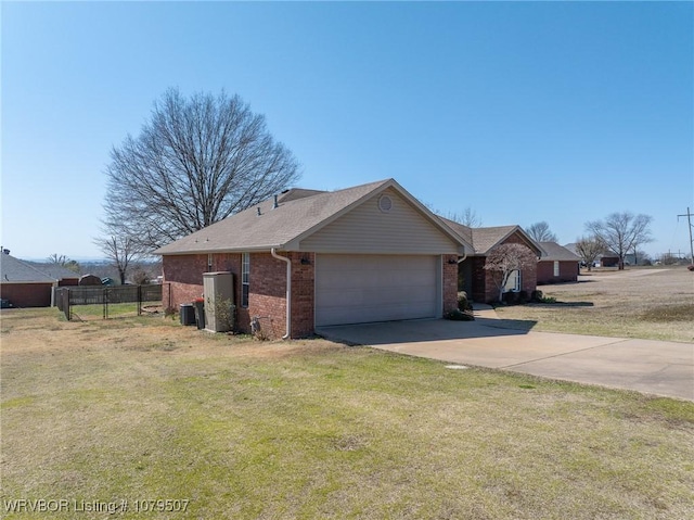 view of side of home featuring a garage, brick siding, concrete driveway, and a yard