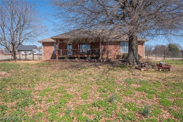 exterior space with brick siding, a front lawn, and fence