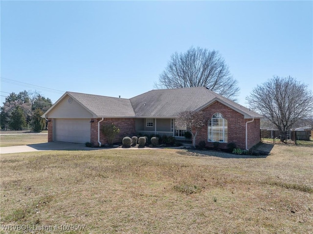 ranch-style home featuring a front yard, brick siding, concrete driveway, and an attached garage