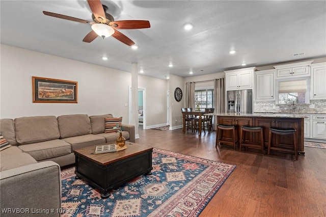 living area with recessed lighting, baseboards, ceiling fan, and dark wood-style flooring