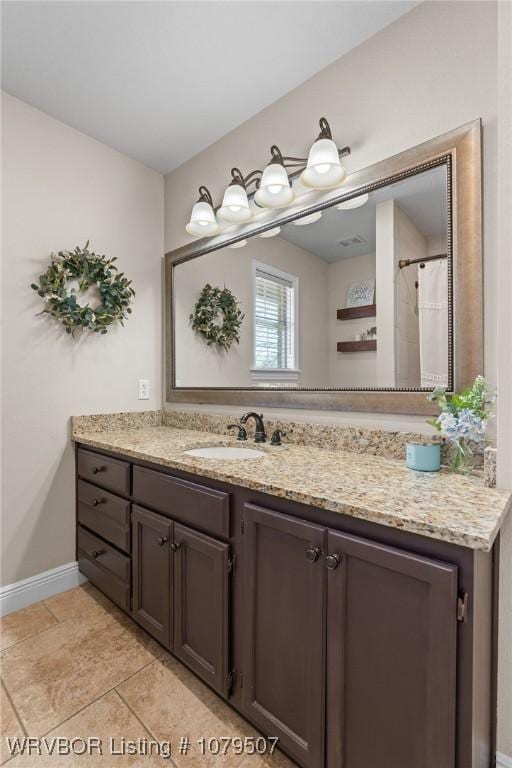 full bath with vanity, baseboards, and tile patterned flooring