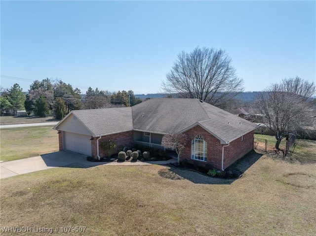 single story home featuring driveway, a front yard, a shingled roof, a garage, and brick siding