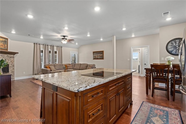 kitchen with a center island, a ceiling fan, dark wood-type flooring, and black electric stovetop