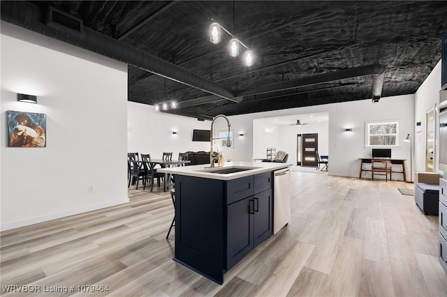 kitchen featuring a sink, visible vents, light countertops, light wood-type flooring, and dishwasher