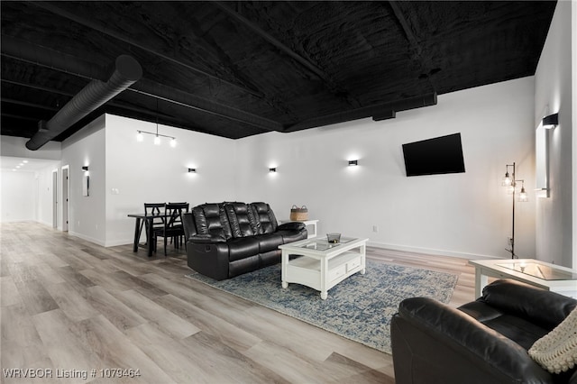 living area with baseboards and wood finished floors