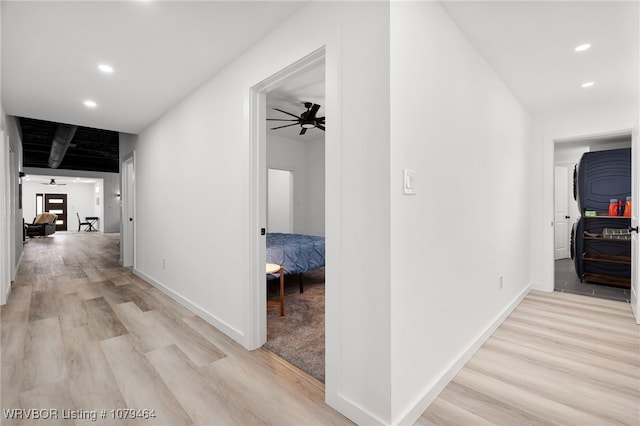 corridor featuring light wood-type flooring, baseboards, and recessed lighting