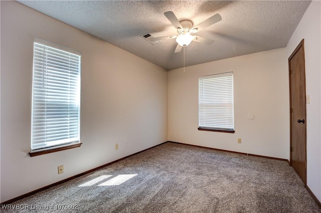 unfurnished room with carpet flooring, ceiling fan, a textured ceiling, and a wealth of natural light