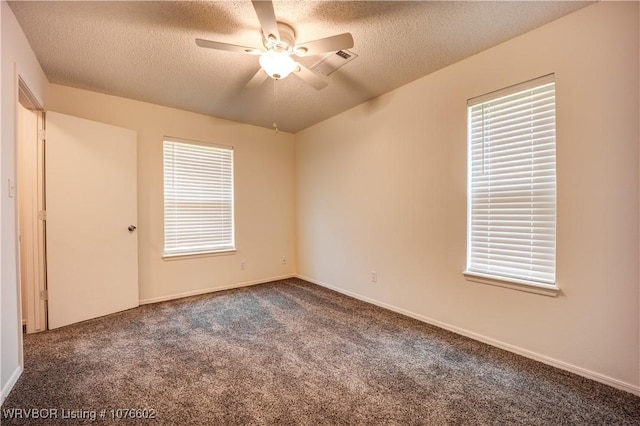 carpeted empty room featuring ceiling fan and a textured ceiling