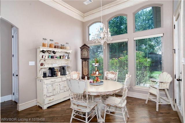 dining room with dark hardwood / wood-style floors, crown molding, and a notable chandelier