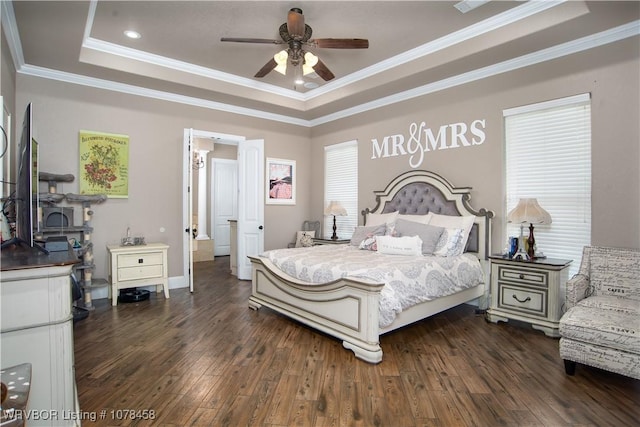 bedroom with dark hardwood / wood-style floors, ceiling fan, ornamental molding, and a raised ceiling