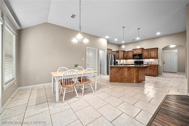 1075 Maple Ridge Dr, Greenwood, AR 72936 - kitchen with visible vents, a sink, a kitchen island with sink, black microwave, and arched walkways