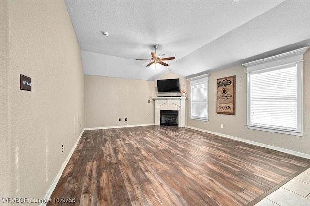 1075 Maple Ridge Dr, Greenwood, AR 72936 - unfurnished living room with a ceiling fan, vaulted ceiling, a tiled fireplace, and wood finished floors