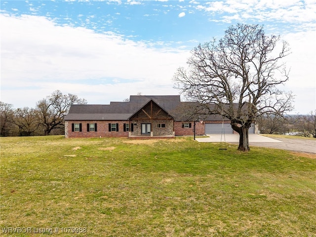 view of front of home featuring driveway, brick siding, and a front yard