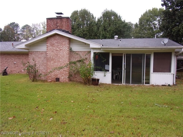 back of house with a yard and a sunroom