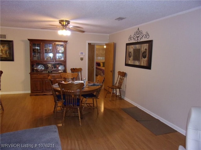 dining space featuring ceiling fan, wood-type flooring, and a textured ceiling