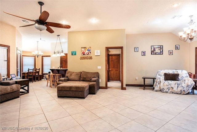 tiled living room featuring vaulted ceiling and ceiling fan with notable chandelier