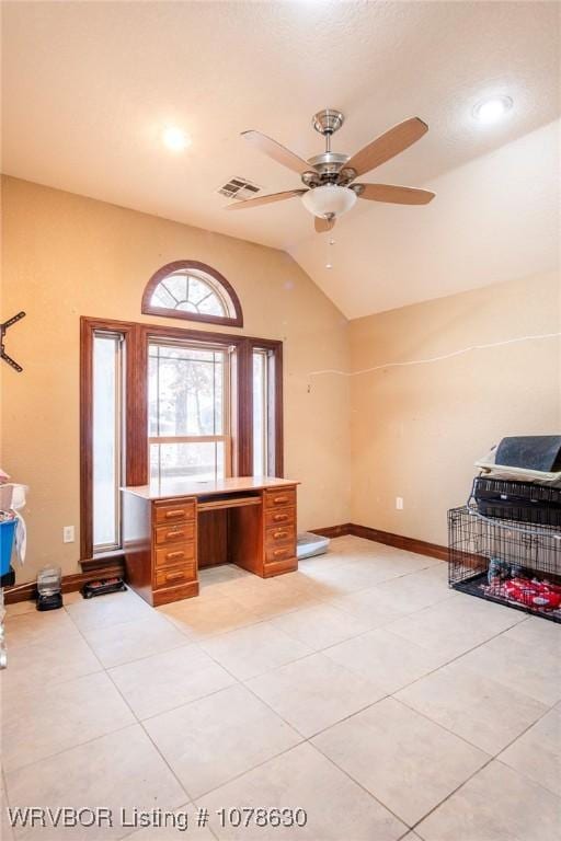 unfurnished office with lofted ceiling, ceiling fan, and light tile patterned flooring