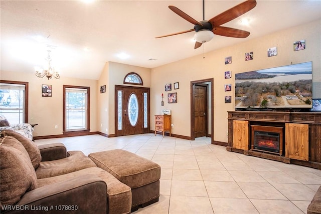 tiled living room with ceiling fan with notable chandelier