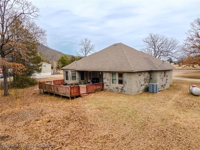 back of house featuring a wooden deck, central AC unit, and a yard