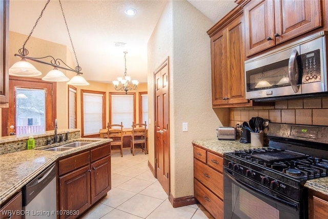 kitchen featuring stainless steel appliances, sink, pendant lighting, and light tile patterned floors