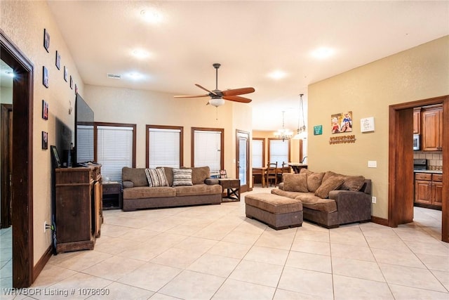 living room featuring ceiling fan with notable chandelier and light tile patterned floors