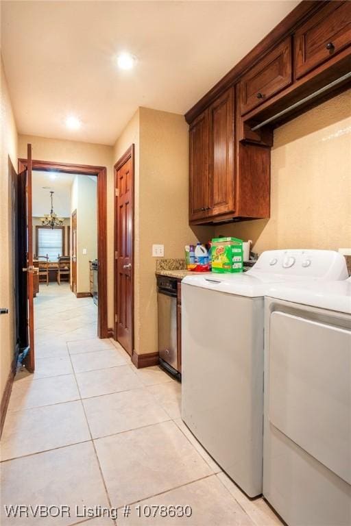 washroom featuring cabinets, washer and dryer, light tile patterned floors, and a chandelier