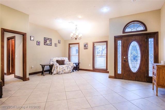 foyer entrance with lofted ceiling, a chandelier, and light tile patterned floors