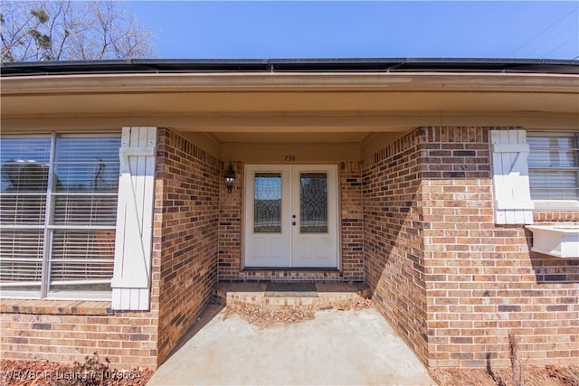 property entrance with brick siding, solar panels, and french doors