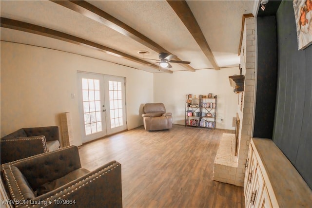 living area with visible vents, ceiling fan, beam ceiling, french doors, and wood finished floors