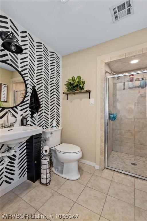 bathroom featuring toilet, tile patterned floors, and walk in shower