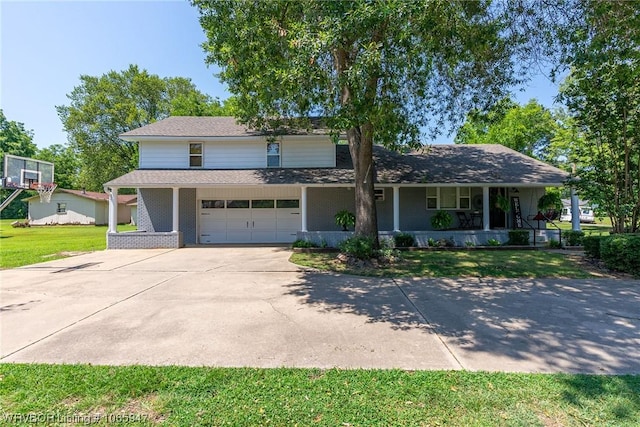 view of property featuring covered porch, a garage, and a front lawn