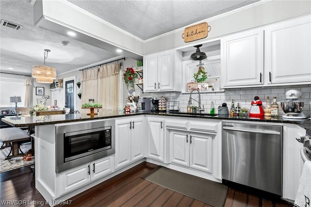 kitchen featuring white cabinets, sink, stainless steel appliances, and a textured ceiling