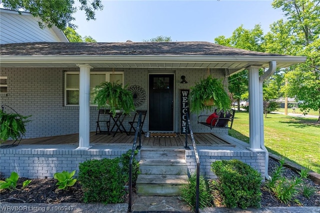 entrance to property with a lawn and a porch