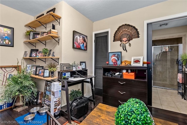 tiled office space featuring a textured ceiling