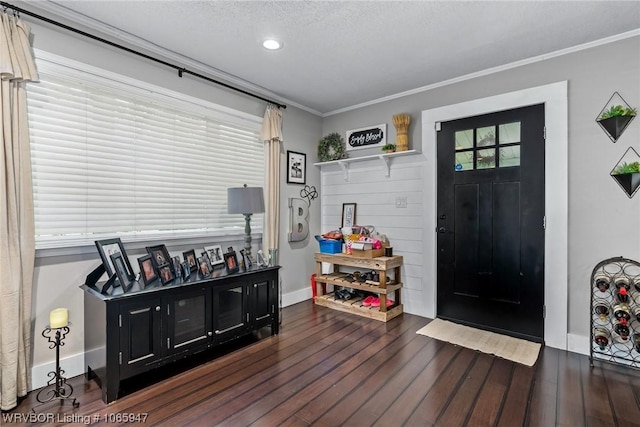 foyer with a textured ceiling, dark hardwood / wood-style flooring, and crown molding