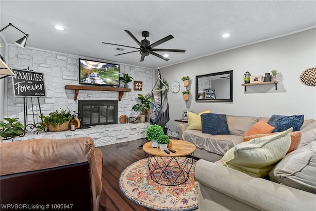 living room featuring ceiling fan, crown molding, wood-type flooring, and a fireplace