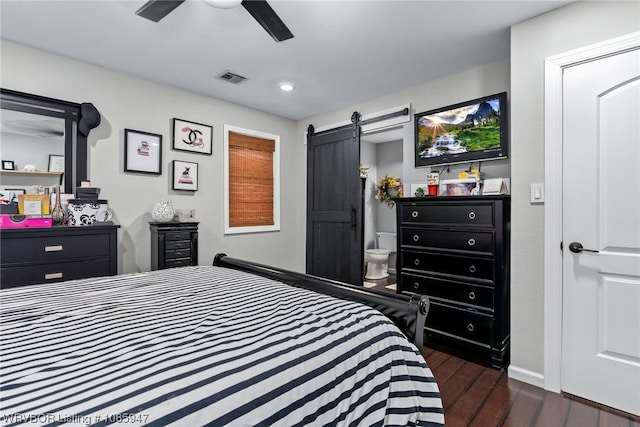 bedroom featuring a barn door, ceiling fan, and dark wood-type flooring